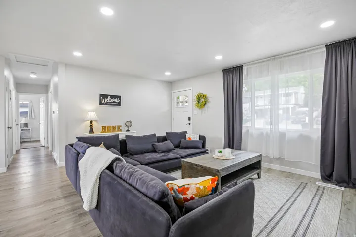 Recessed ceiling lighting illuminates the living space with wood-finish flooring