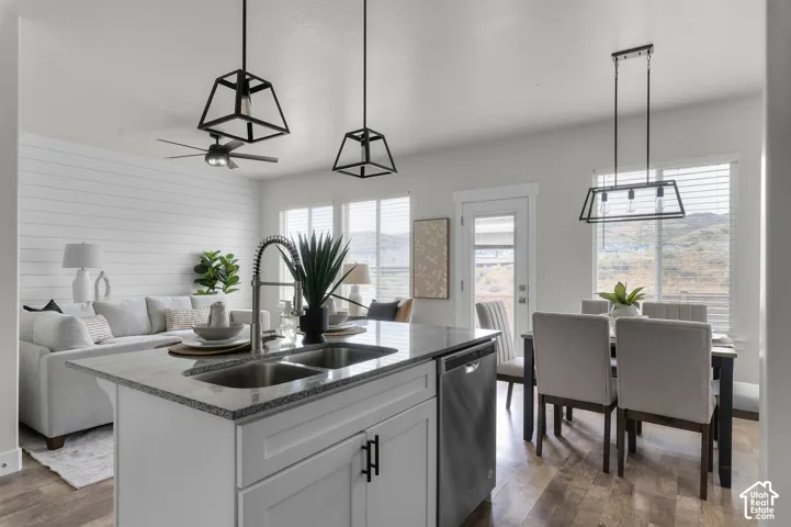 Kitchen island with dual stainless steel sink, granite-style countertop, and integrated dishwasher
