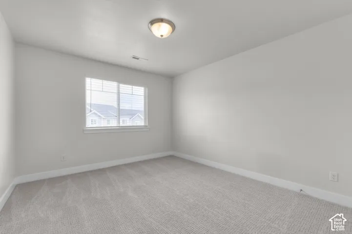 Neutral tone wall finishes, gray patterned carpeting, a window with horizontal blinds, and a semi-flush mount ceiling light fixture