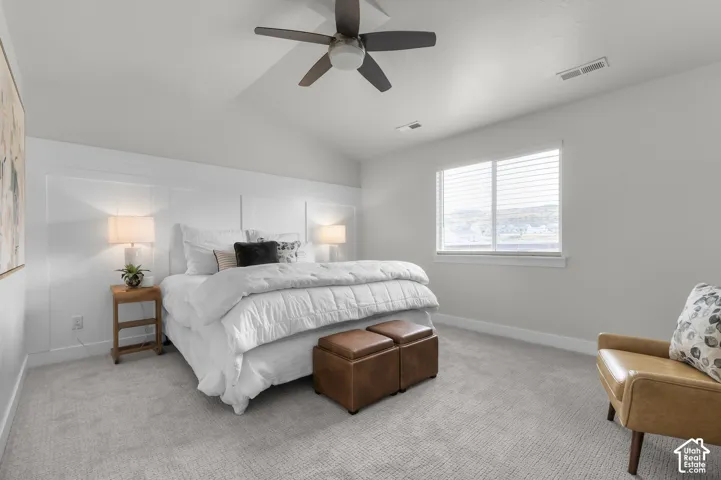 Vaulted ceiling with a ceiling fan, white paneled accent wall, neutral carpet flooring, and a window with blinds