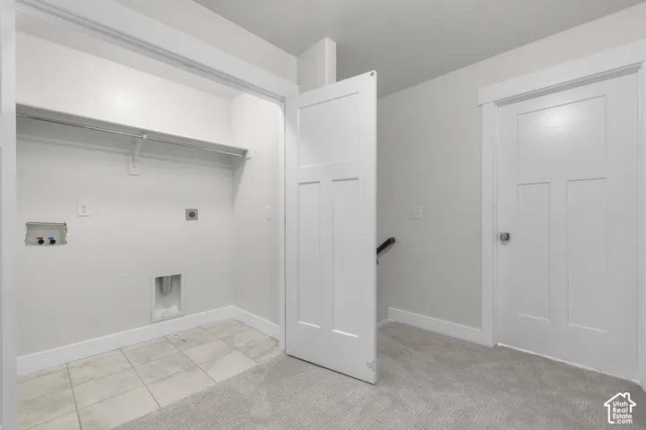 Dedicated laundry alcove with tile flooring, white walls, and built-in shelving