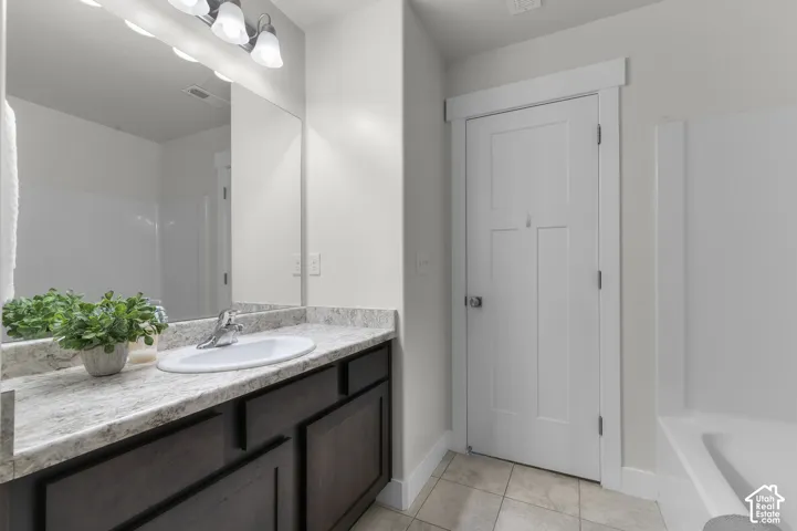 Integrated vanity with a single basin, dark wood-finish cabinetry, and a light-toned countertop