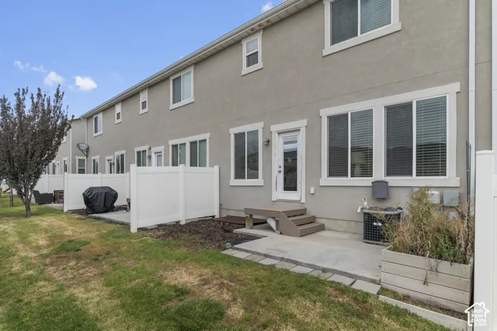 Private patio with composite steps, vinyl fencing, and stucco exterior
