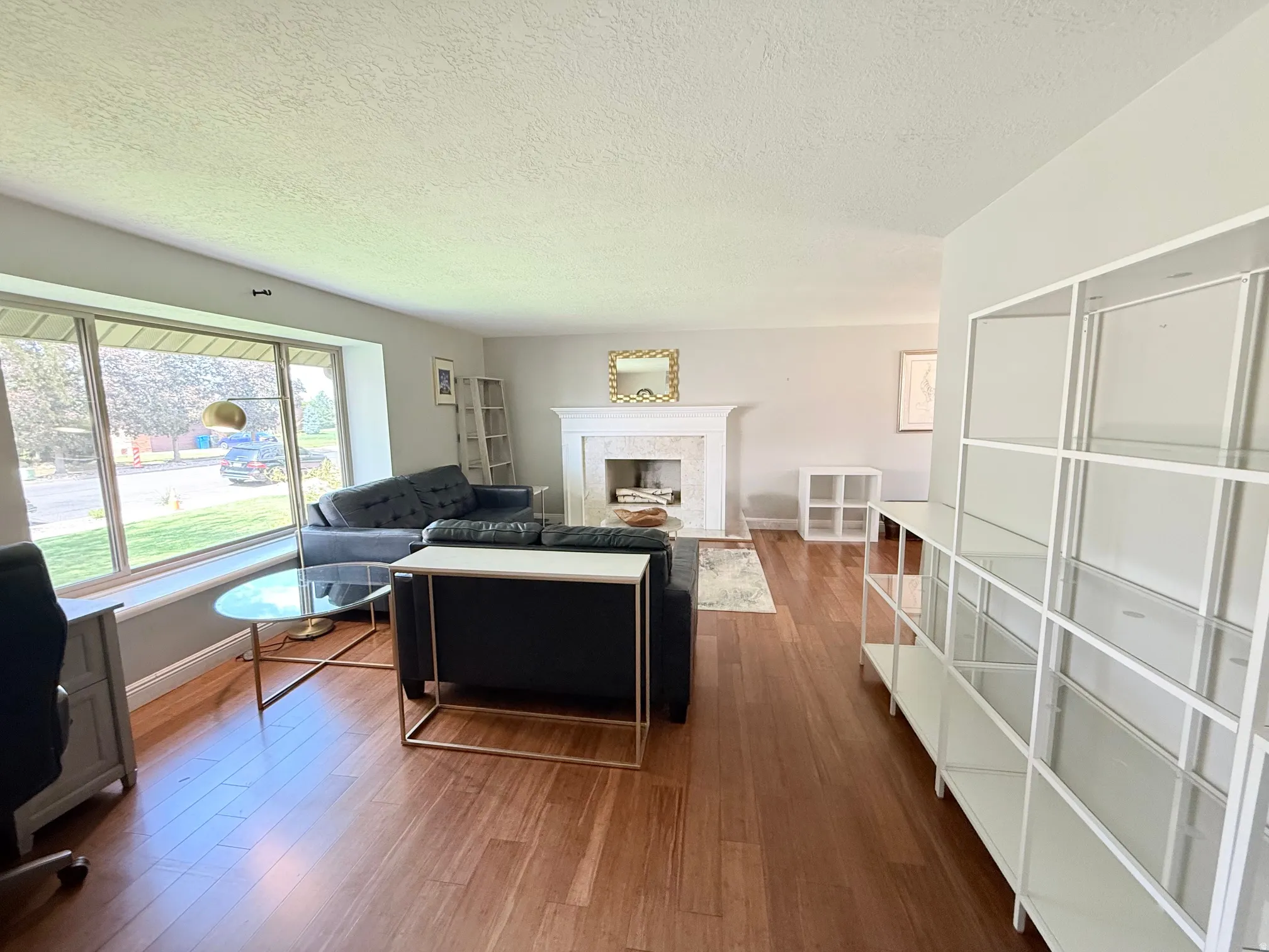 Hardwood flooring throughout, large picture window, and a built-in fireplace