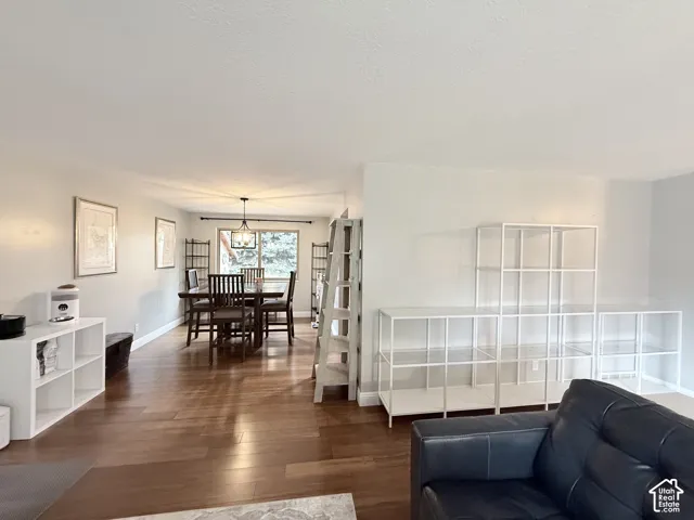 Open-concept interior featuring wood-finish flooring, neutral wall paint, and a multi-arm overhead pendant light