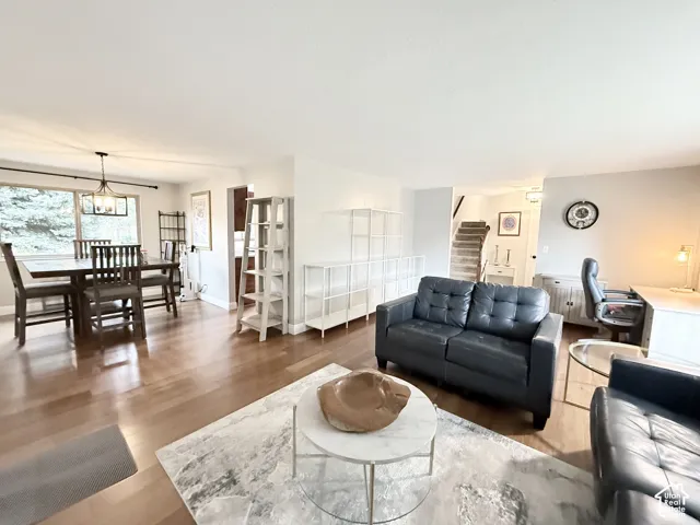 Open-concept interior featuring wood-finish flooring, neutral wall paint, and a multi-light fixture