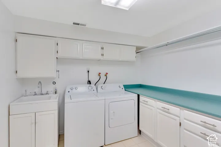 Built-in utility sink with white cabinetry, upper white storage cabinets, and a light blue countertop with additional lower cabinetry