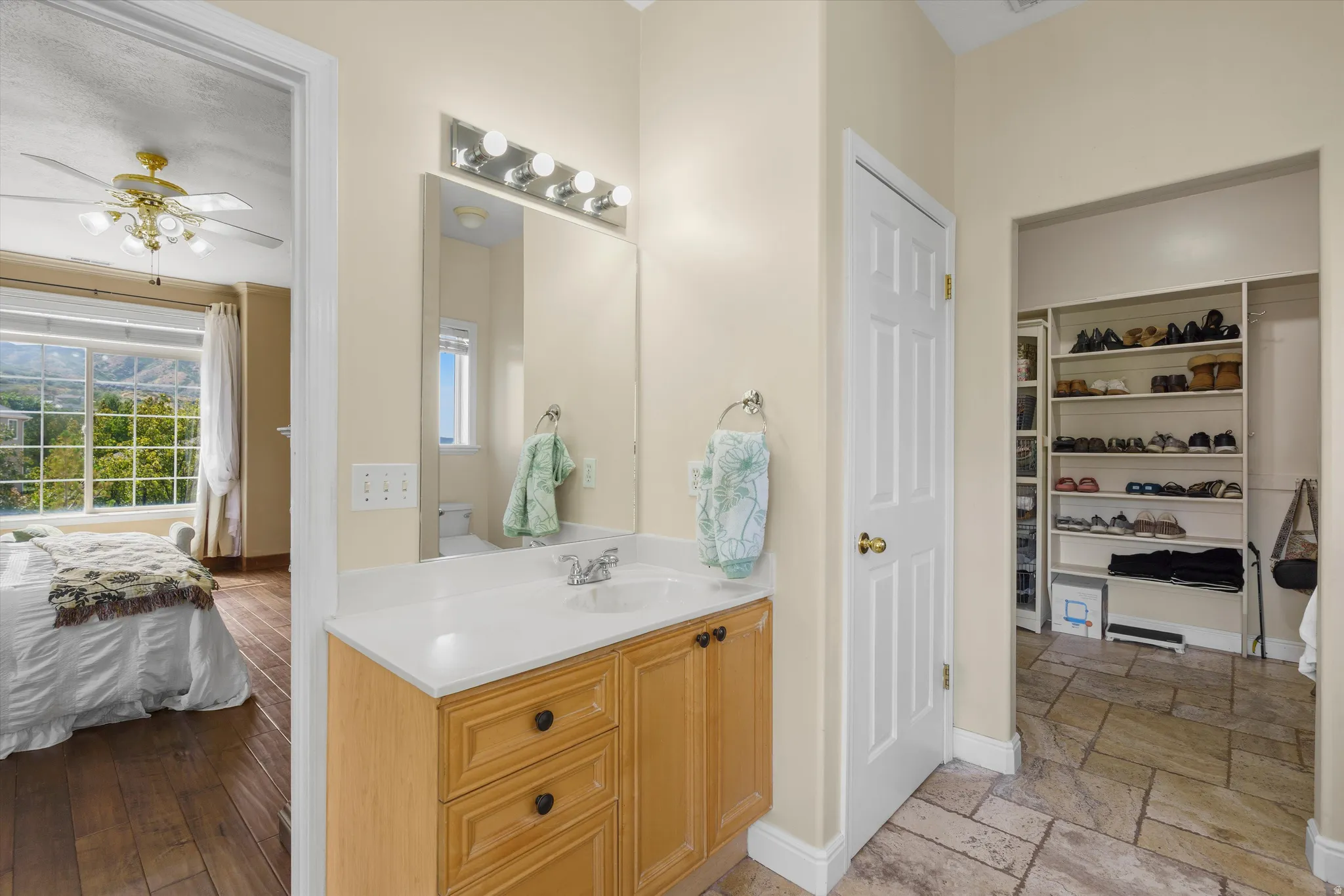Bathroom vanity with wood-finish cabinetry and a white countertop