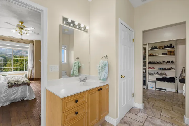 Bathroom vanity with wood-finish cabinetry and a white countertop