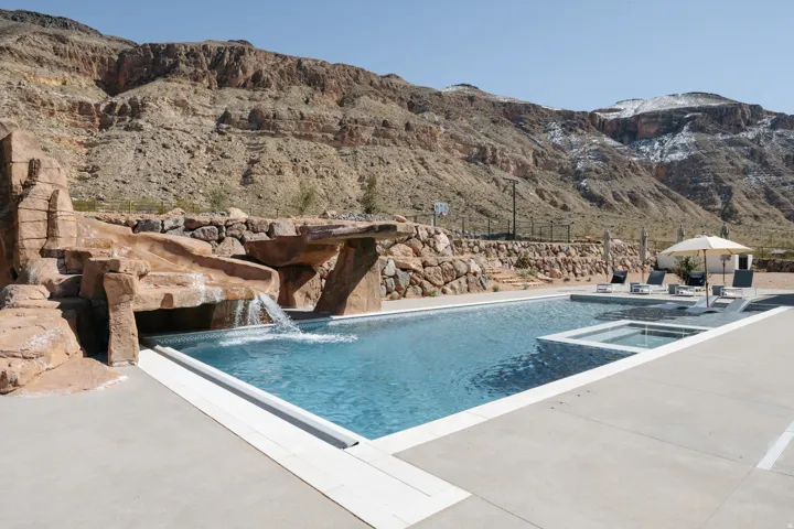 Swimming pool with integrated spa and rock-feature waterslide