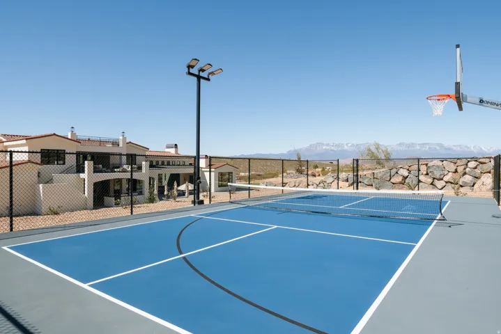 Multi-sport court with a tennis net and basketball hoop