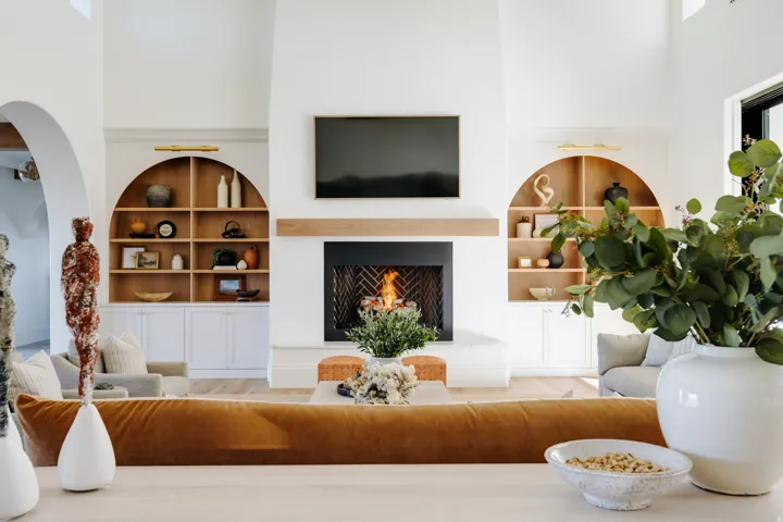 Vaulted ceilings with a prominent fireplace featuring a wood mantel
