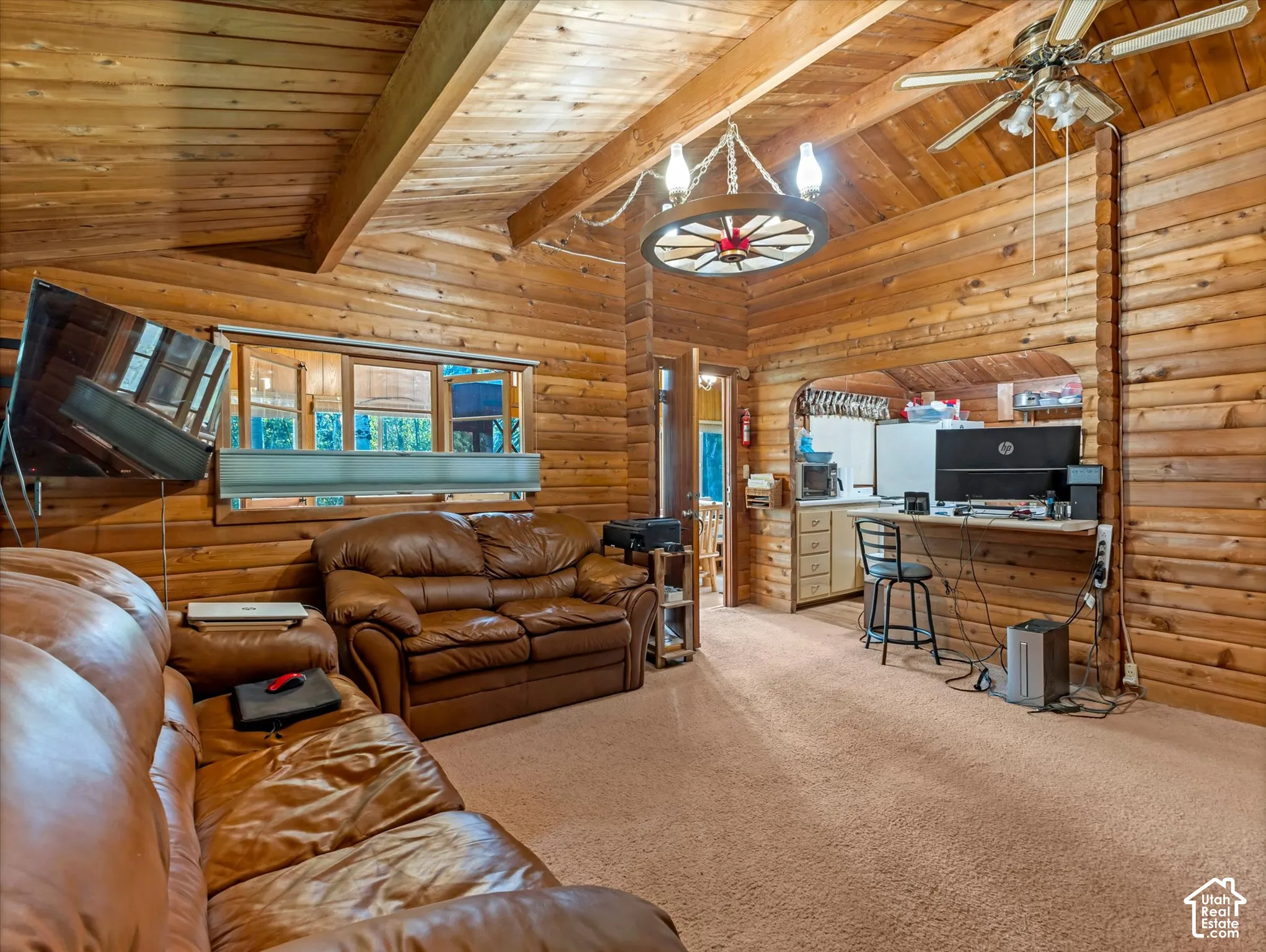 Vaulted wood-paneled ceiling with exposed beams, wood-plank walls, and an arched pass-through opening