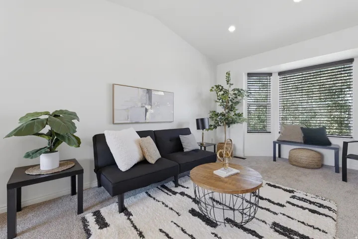 Vaulted ceiling, recessed lighting, expansive bay window with blinds, and carpeted flooring