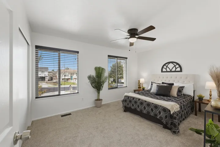 Carpeted flooring, white walls, and a ceiling fan with integrated lighting