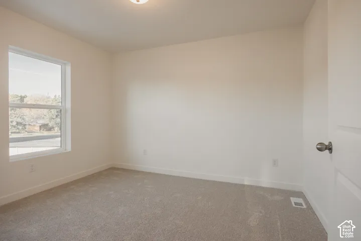 Bedroom 2 - Neutral-toned walls with light gray carpeting and a white trim