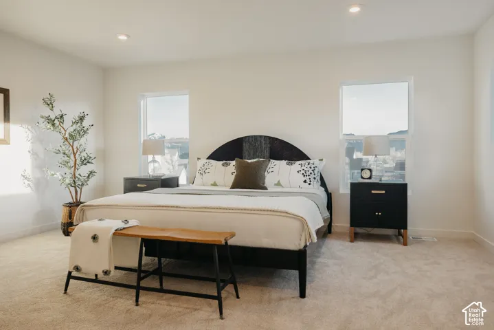 Primary Bedroom. Recessed lighting illuminates neutral-toned carpet and white walls