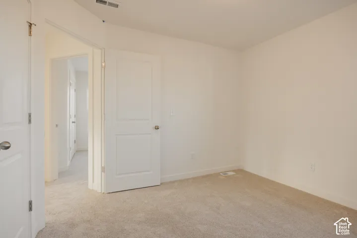 Bedroom 2 - Neutral wall color, light-toned carpet, and white paneled doors