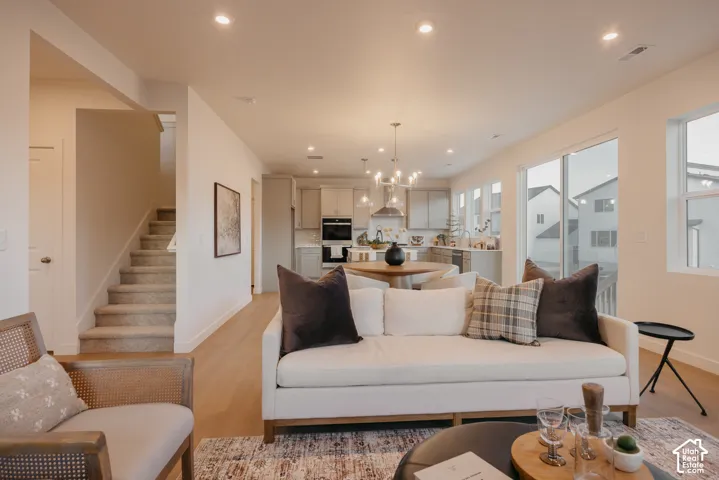 Open-concept living area with wood-finish flooring, recessed lighting, and a sliding glass door