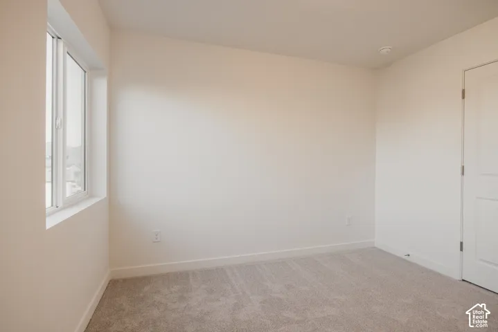 Bedroom 3 - Neutral wall paint, carpet flooring, and a single window