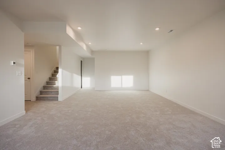 Huge basement living room - Spacious room with plush carpeting, recessed lighting, and white painted walls