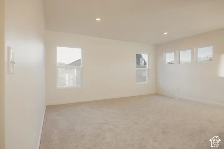 Loft - Spacious room featuring neutral carpeting, multiple windows, recessed lighting, and light-toned wall finishes