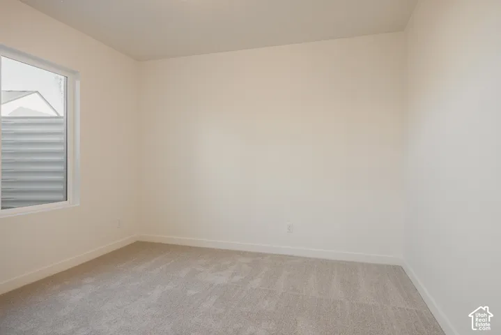 Bedroom 5 - Neutral-toned carpeting and light-colored walls