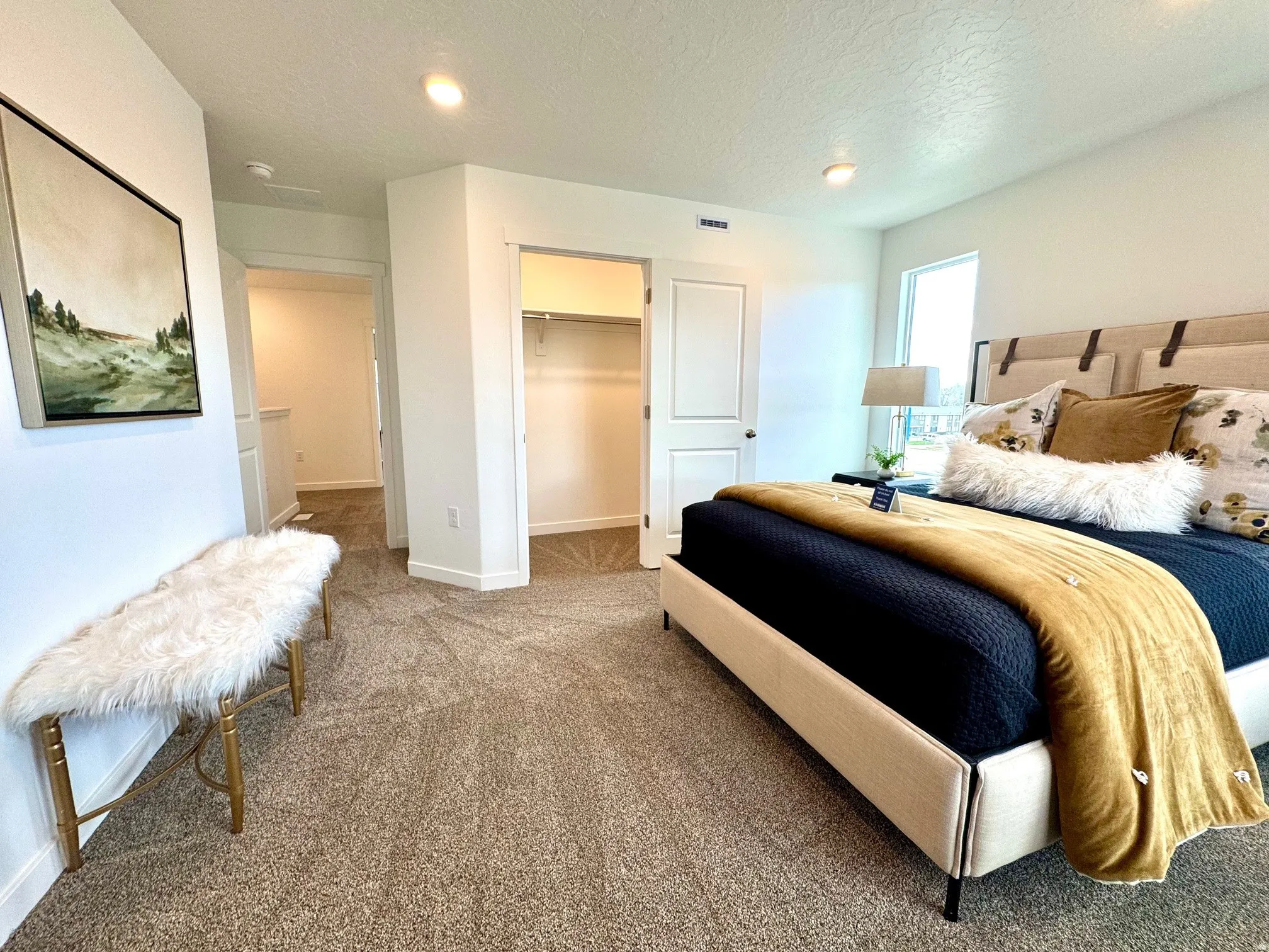 Recessed lighting, window with natural light, neutral carpeting, and a built-in closet with shelving and hanging rod