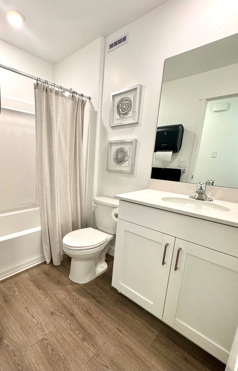 White vanity with shaker-style cabinetry, a white countertop, and an undermount sink