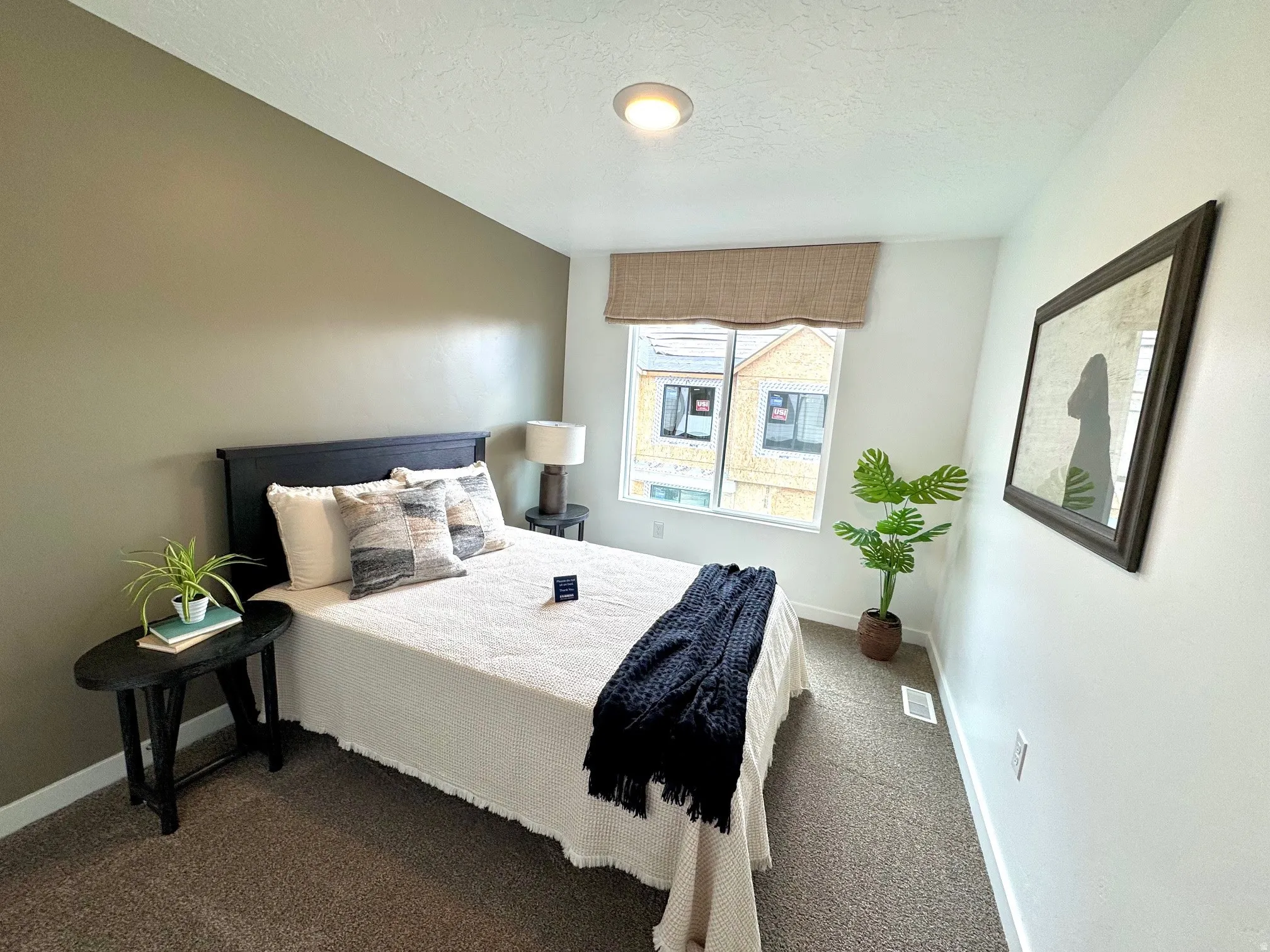 Carpeted room with a recessed ceiling light, a window with a woven shade, and a contrasting accent wall