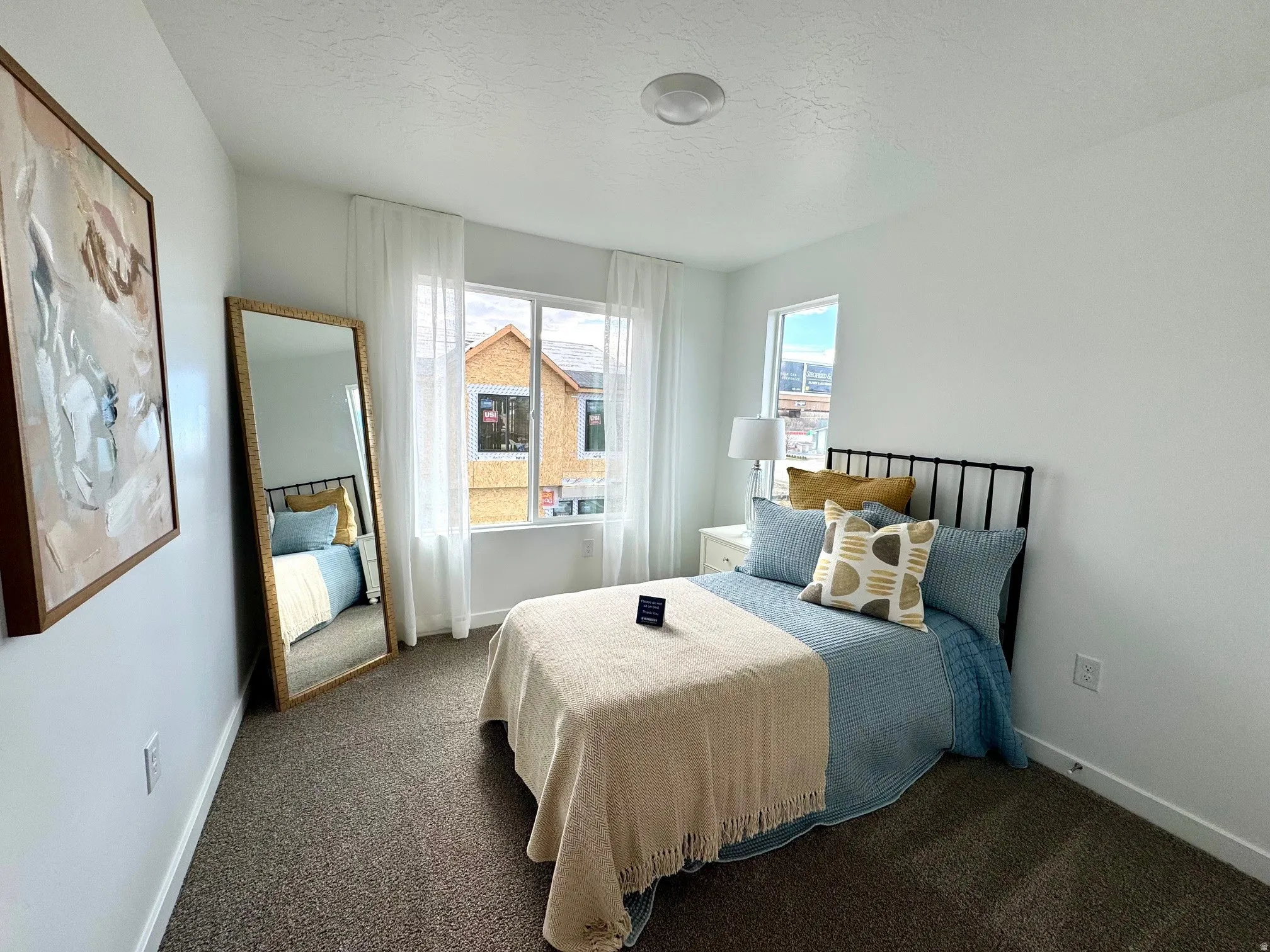 Bright room with neutral wall paint, carpet flooring, a large window, and recessed lighting