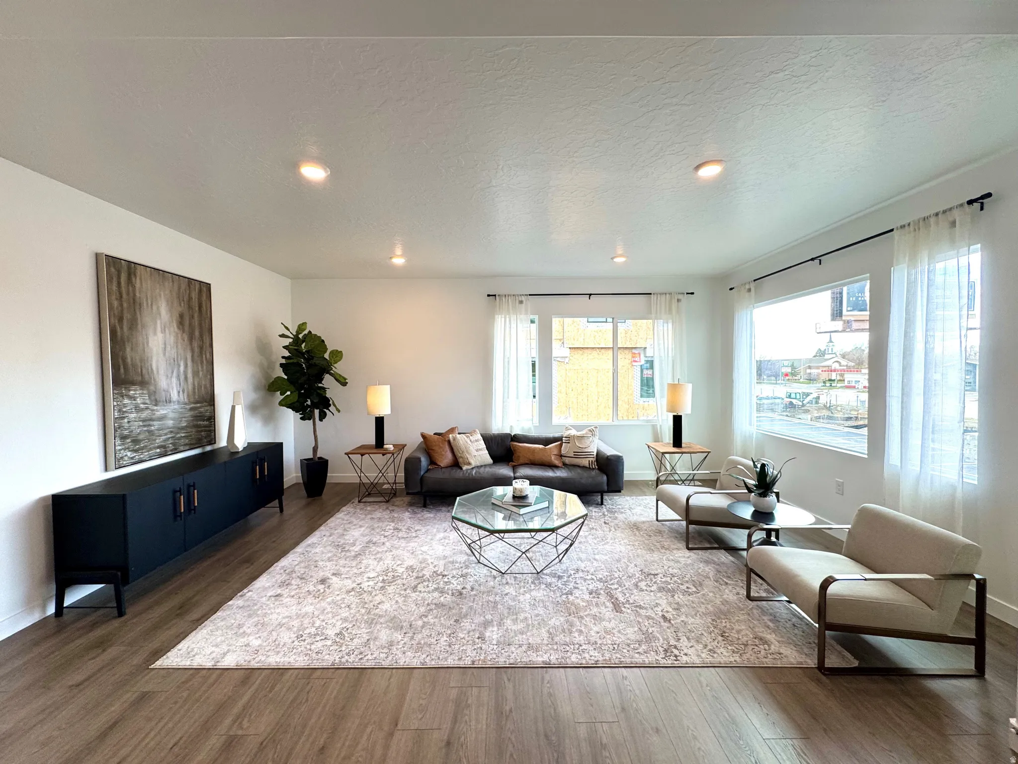 Recessed lighting, wood-finish flooring, multiple windows, and white walls