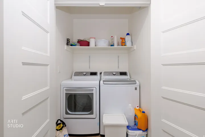 Built-in laundry closet with two panel doors and an integrated shelf
