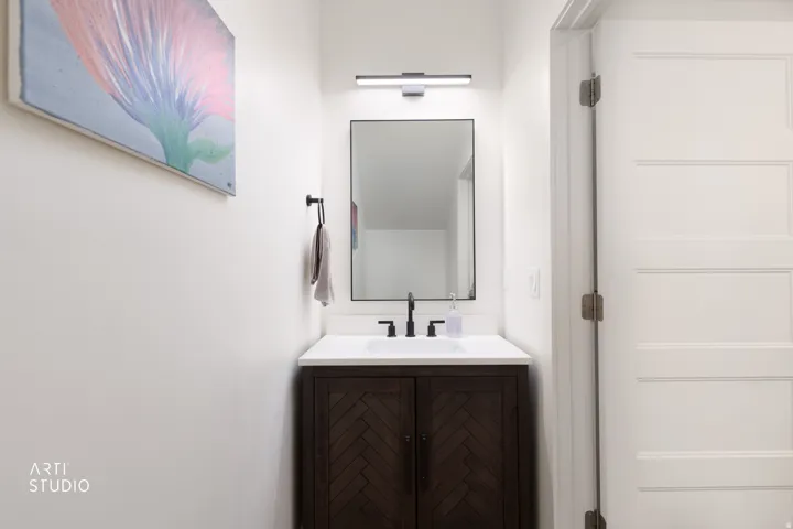 Dark wood-finish vanity with herringbone pattern doors, white countertop, and rectangular undermount sink