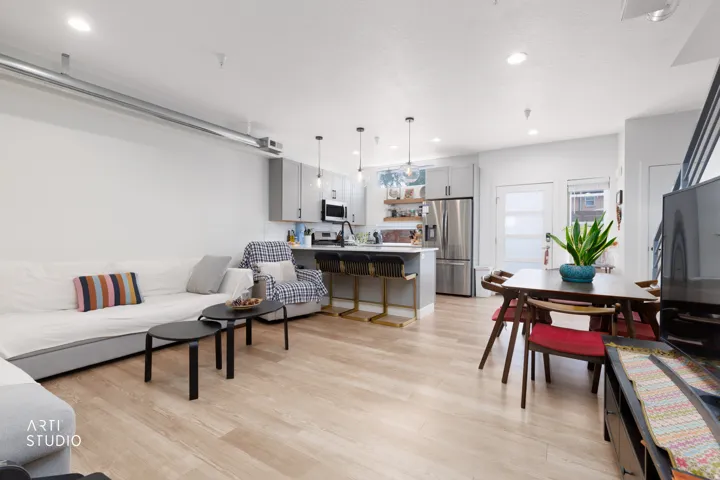 Open-concept living space featuring wood-finish flooring, recessed lighting, and exposed ductwork