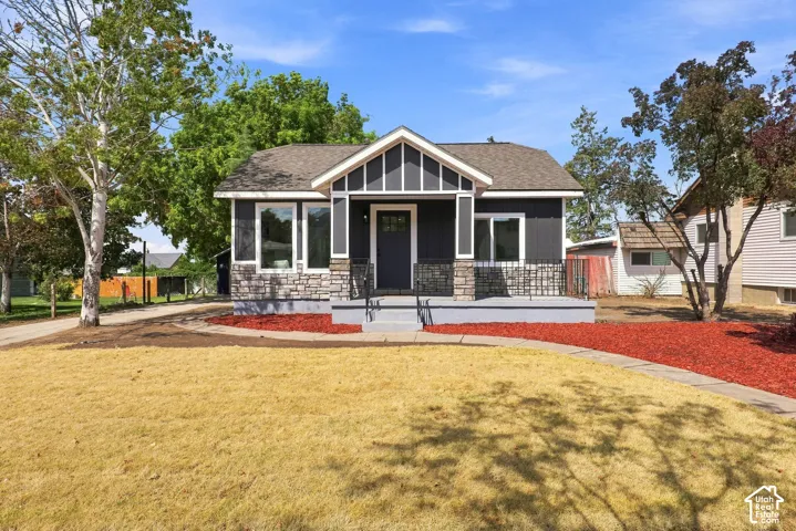 Dark gray siding with white trim accents and stone veneer detailing