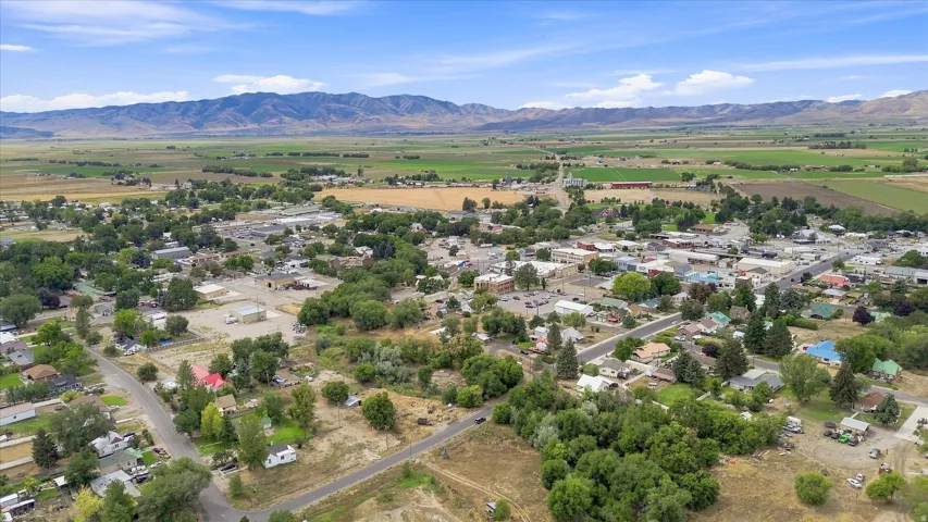 Expansive urban landscape with a backdrop of distant mountains and surrounding agricultural fields