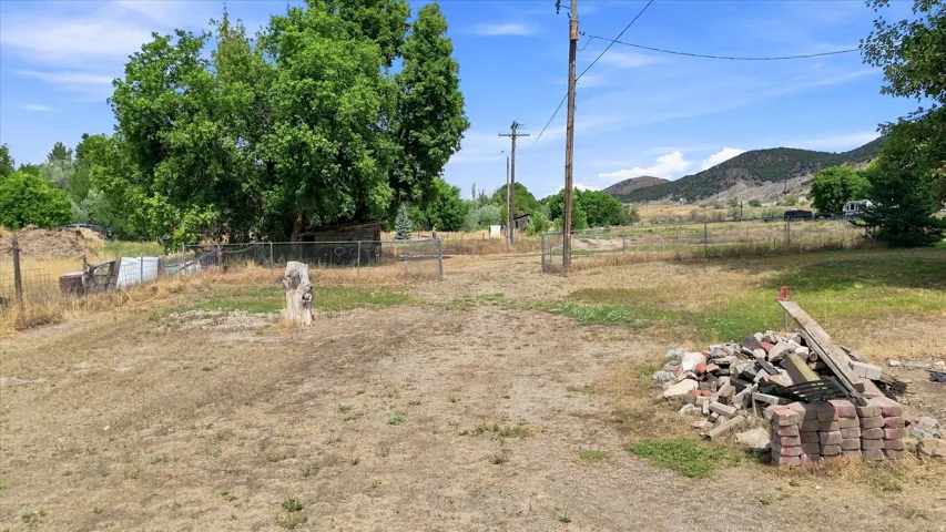 Expansive lot featuring mature trees and distant mountain terrain