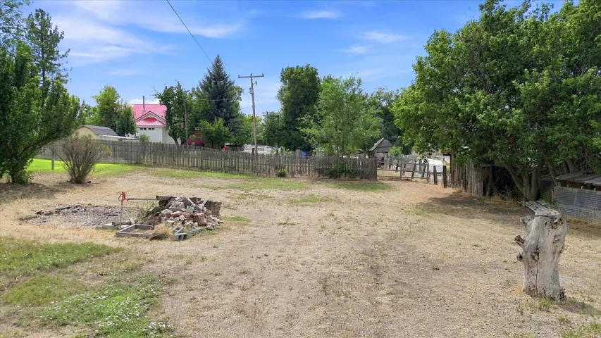 Expansive outdoor space featuring mature trees and partial fencing