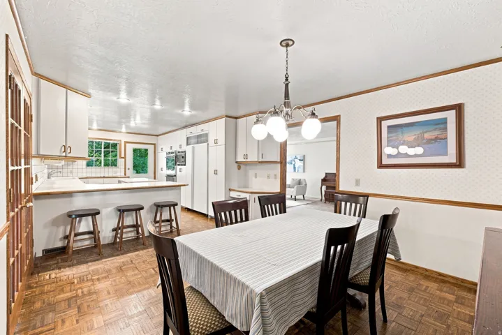 Kitchen featuring white cabinetry, a peninsula with seating, and a tile backsplash