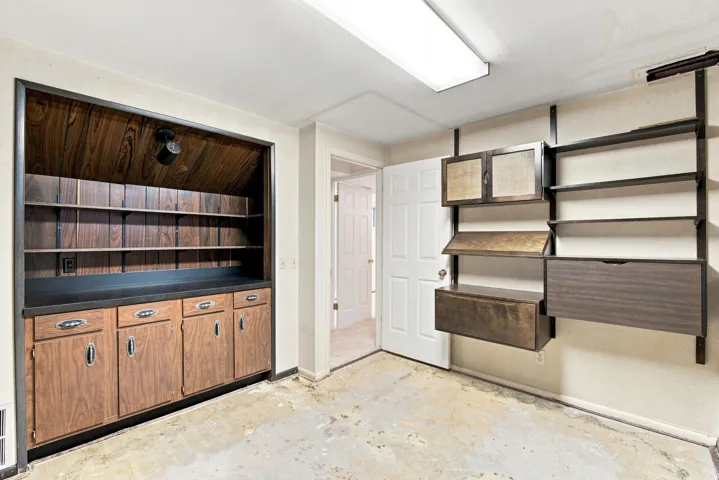 Built-in cabinetry with wood-finish doors, open shelving, integrated lighting, and modular wall-mounted storage units