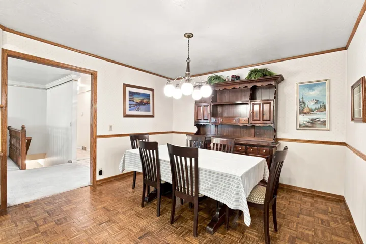 Wood-finish parquet flooring, ceiling light fixture, and wood trim details