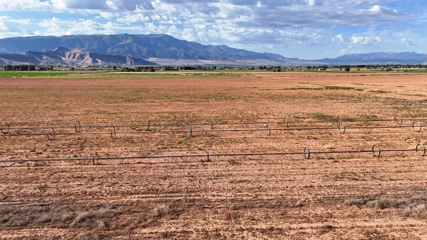 Expansive field with visible irrigation system, surrounded by distant mountains
