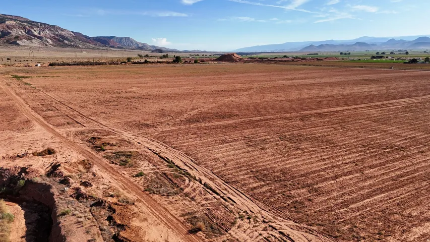 Expansive land parcel featuring arid terrain, distant mountain ranges, and clear skies