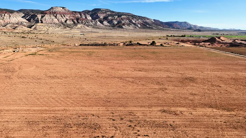 Expansive open terrain featuring a distant mountain range and clear skies