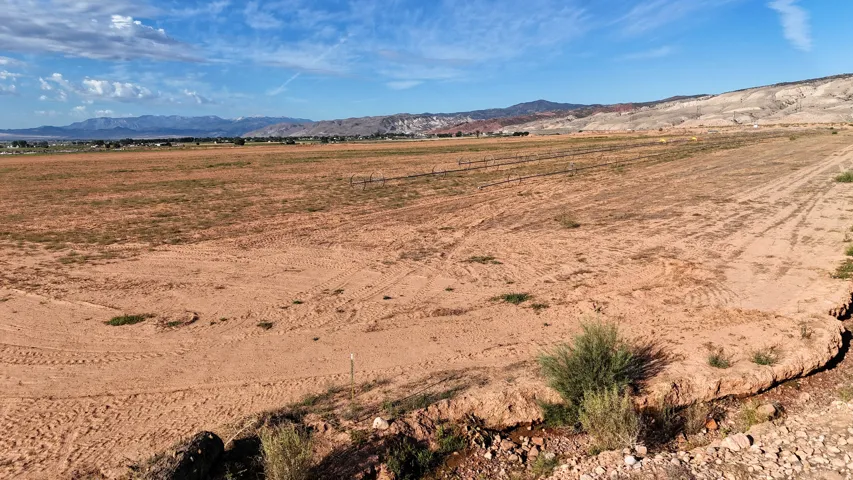 Expansive undeveloped land with distant mountain ranges and clear sky