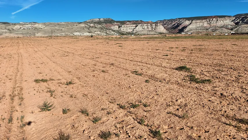 Expansive land parcel featuring exposed earth and distant mountainous terrain