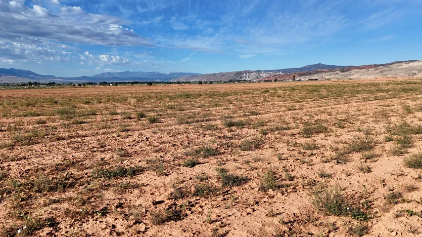 Expansive land area featuring arid terrain and distant mountain ranges
