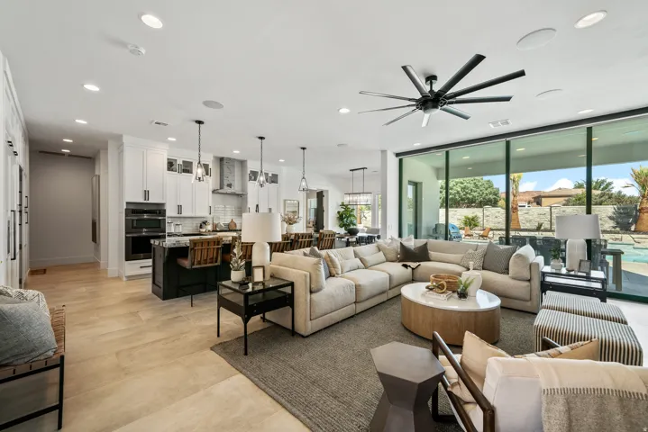 Expansive living area with large format tile flooring and recessed lighting