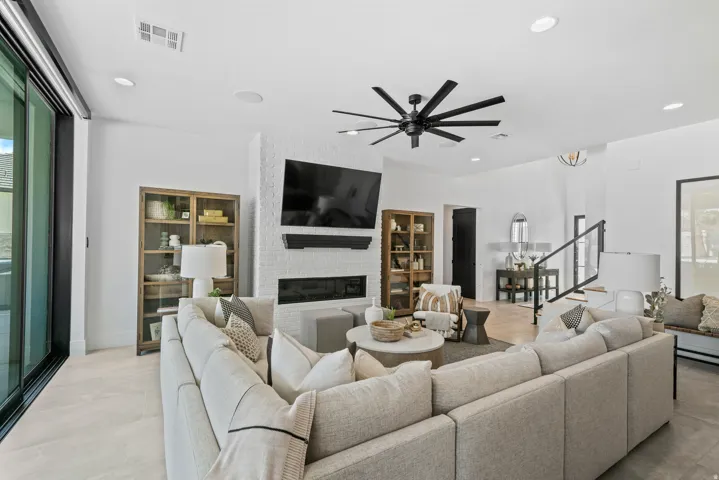 Spacious living area featuring a modern fireplace with a white brick surround, black linear electric insert, and wood mantel